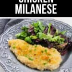 A breaded Chicken Milanese cutlet served with a side of mixed green salad on a decorative gray plate. The text above reads "Classic Chicken Milanese.