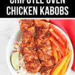 A bowl of rice topped with two chipotle-seasoned oven chicken kabobs, sliced bell peppers, and a lime wedge. The text reads, "Easy Chipotle Oven Chicken Kabobs.