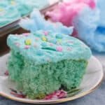 A slice adorned with pastel sprinkles rests on a floral plate, complemented by airy pink and blue background.