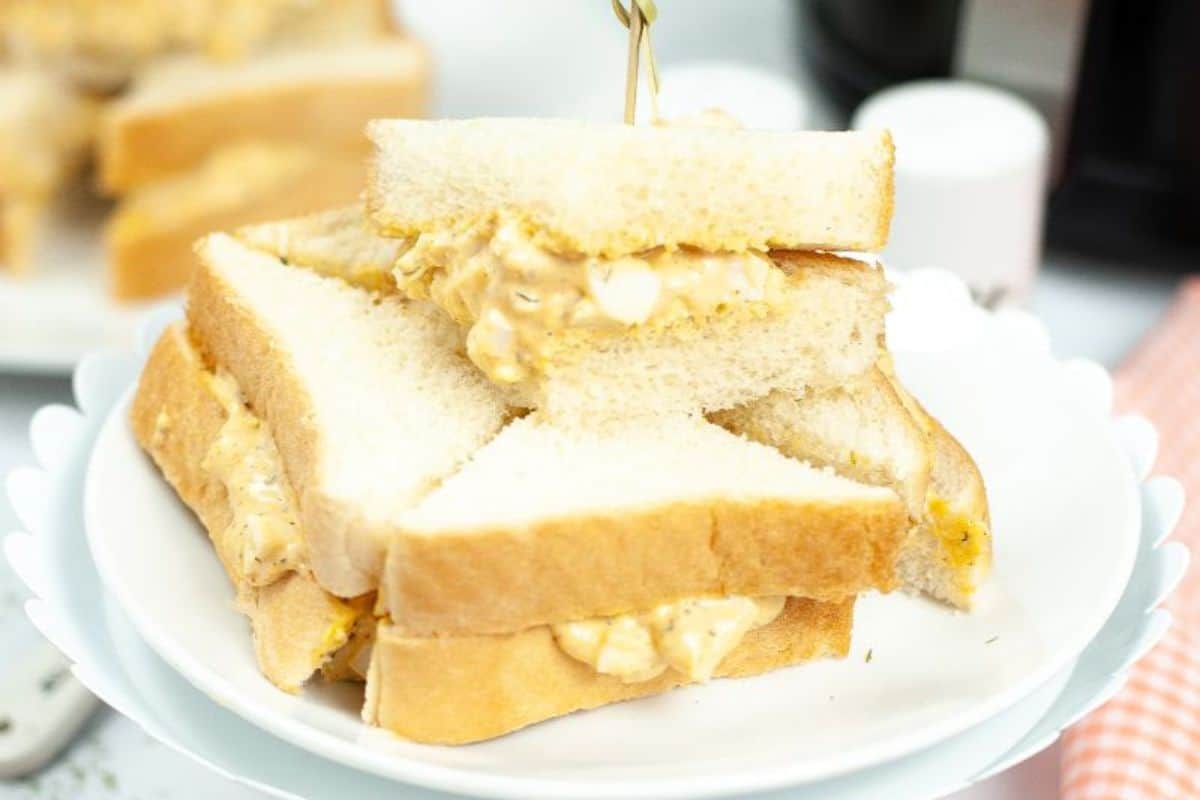 Easy egg salad sandwiches without mustard stacked on a white plate.