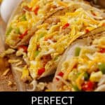 Close-up of egg and sausage tacos with diced vegetables on a wooden board, labeled "perfect egg and sausage tacos.