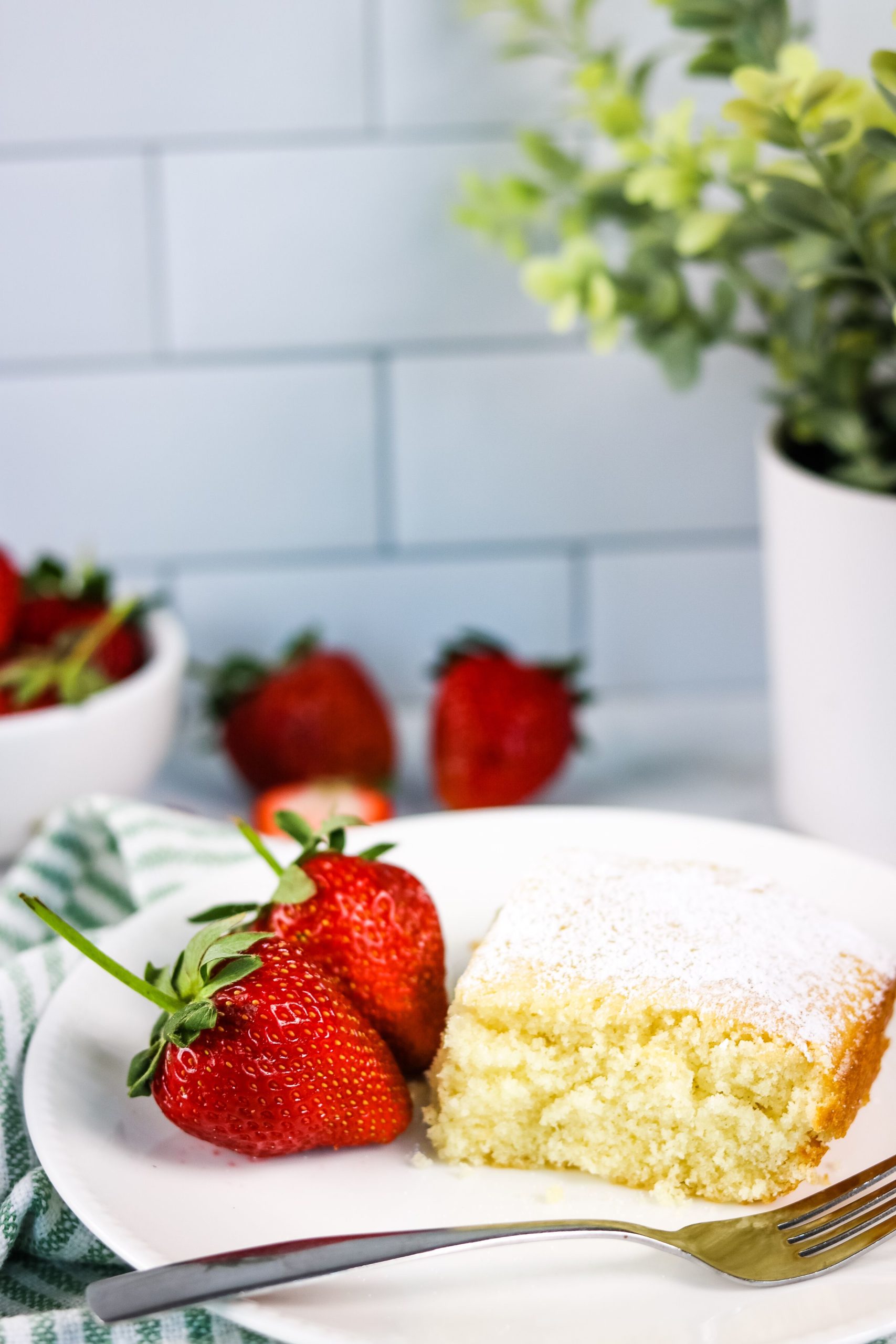 Lazy Cake on a white plate with a side of strawberries.