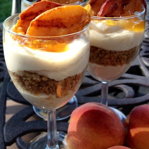 Beautiful Grilled Peach Cheesecake Parfaits in clear glasses.