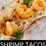 A shrimp taco topped with shredded cabbage, mango salsa, cilantro, and a lime wedge on a flour tortilla. Text reads: "Shrimp Tacos with Mango Salsa—enjoy the perfect mix of flavors in every bite.