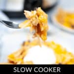 A fork holds a bite of savory Slow Cooker Mexican Chicken Lasagna above a plate, perfectly topped with creamy sour cream.
