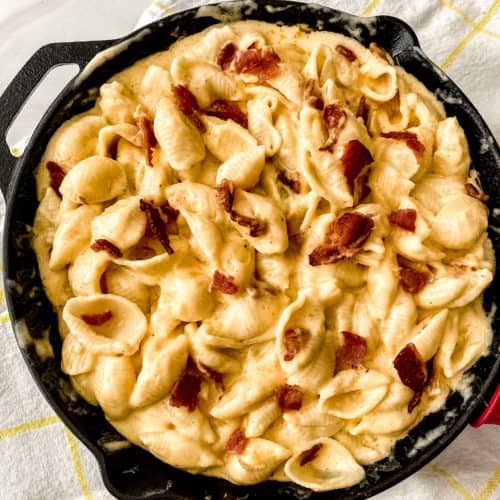 Skillet filled with bacon and cheese.