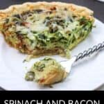 A slice of Spinach and Bacon Quiche rests on a white plate, with a fork lifting a bite-sized piece. In the background, more quiche awaits, showcasing the savory goodness of this classic dish.