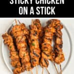 Plate of grilled sticky chicken on a stick arranged in two rows, viewed from above. Text at the top reads, "Grilled Sticky Chicken on a Stick.
