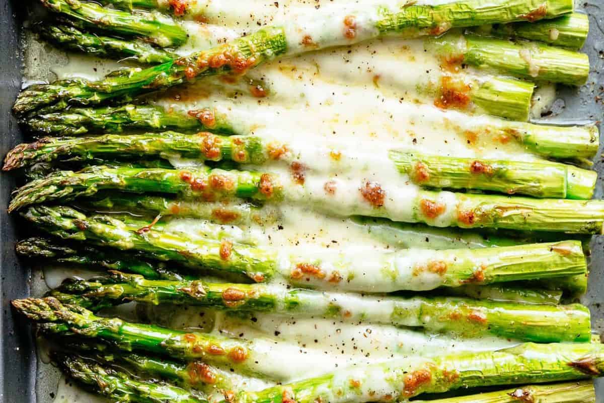 Roasted asparagus spears topped with melted cheese and garlic seasoning.