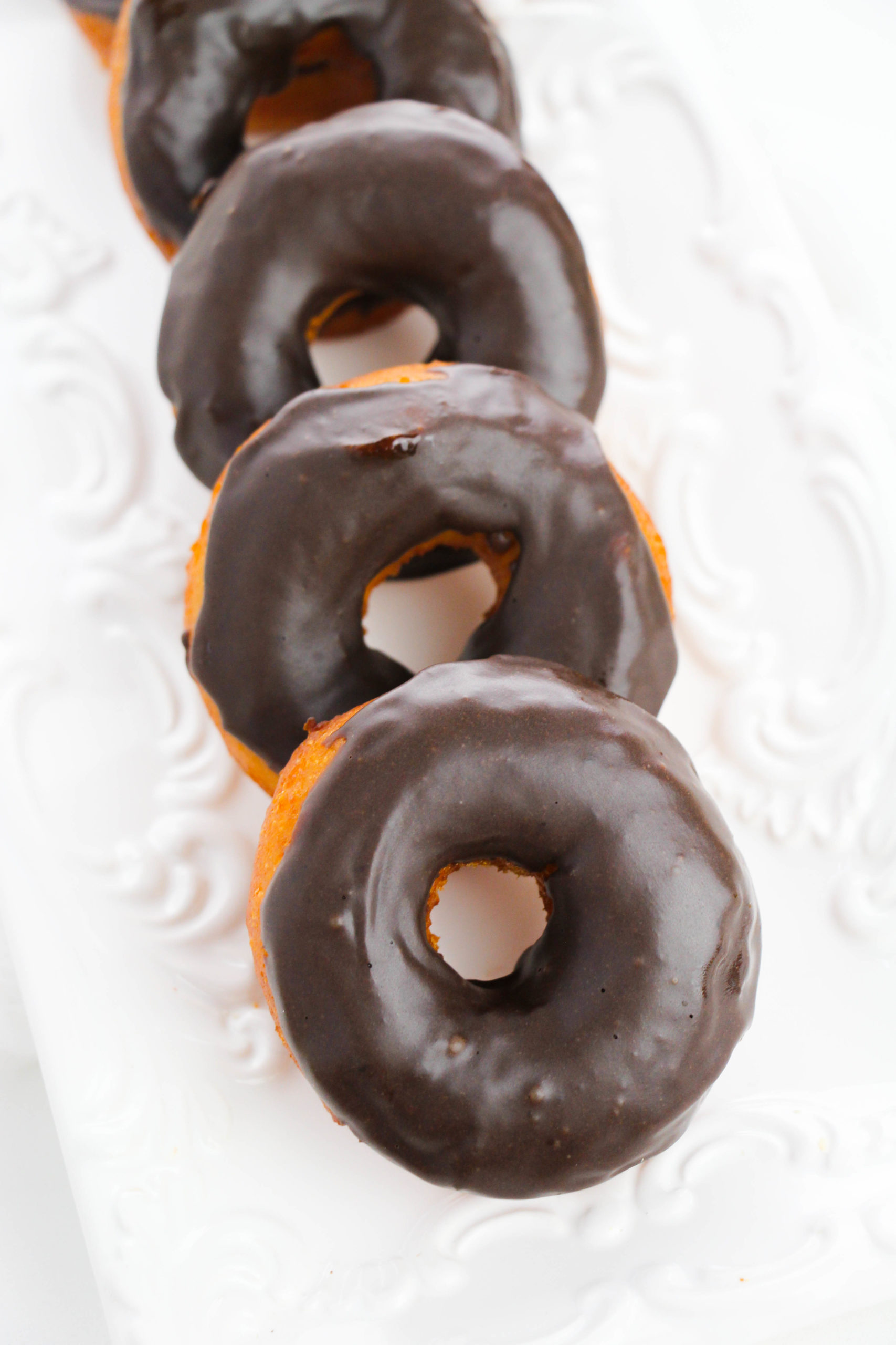 Chocolate Glazed Biscuit Donuts on a white plate