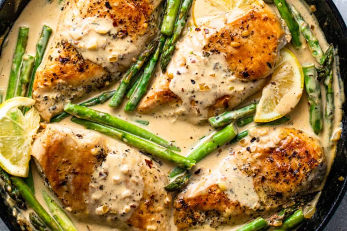 Tender chicken cooked in a creamy lemon sauce served alongside bright green asparagus.