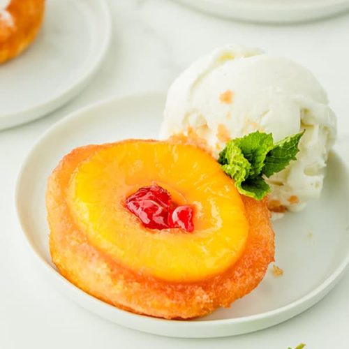 3 Pineapple Upside Down Cakes garnished with vanilla ice cream and a mint leaf