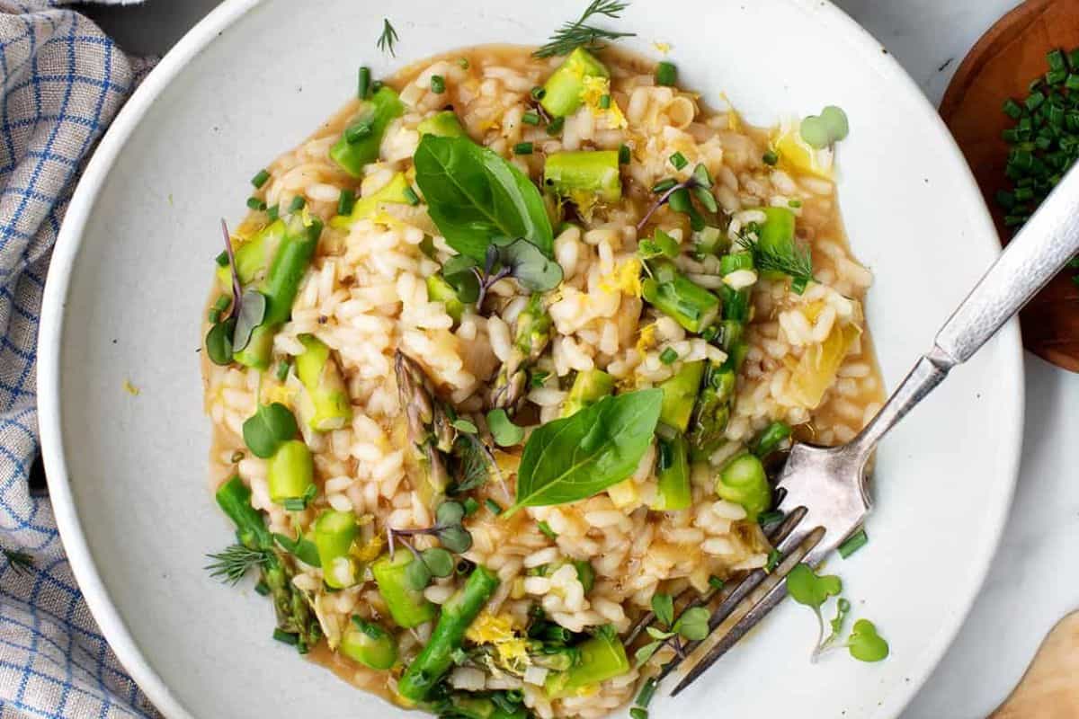A creamy risotto dish topped with tender, bright green asparagus spears.