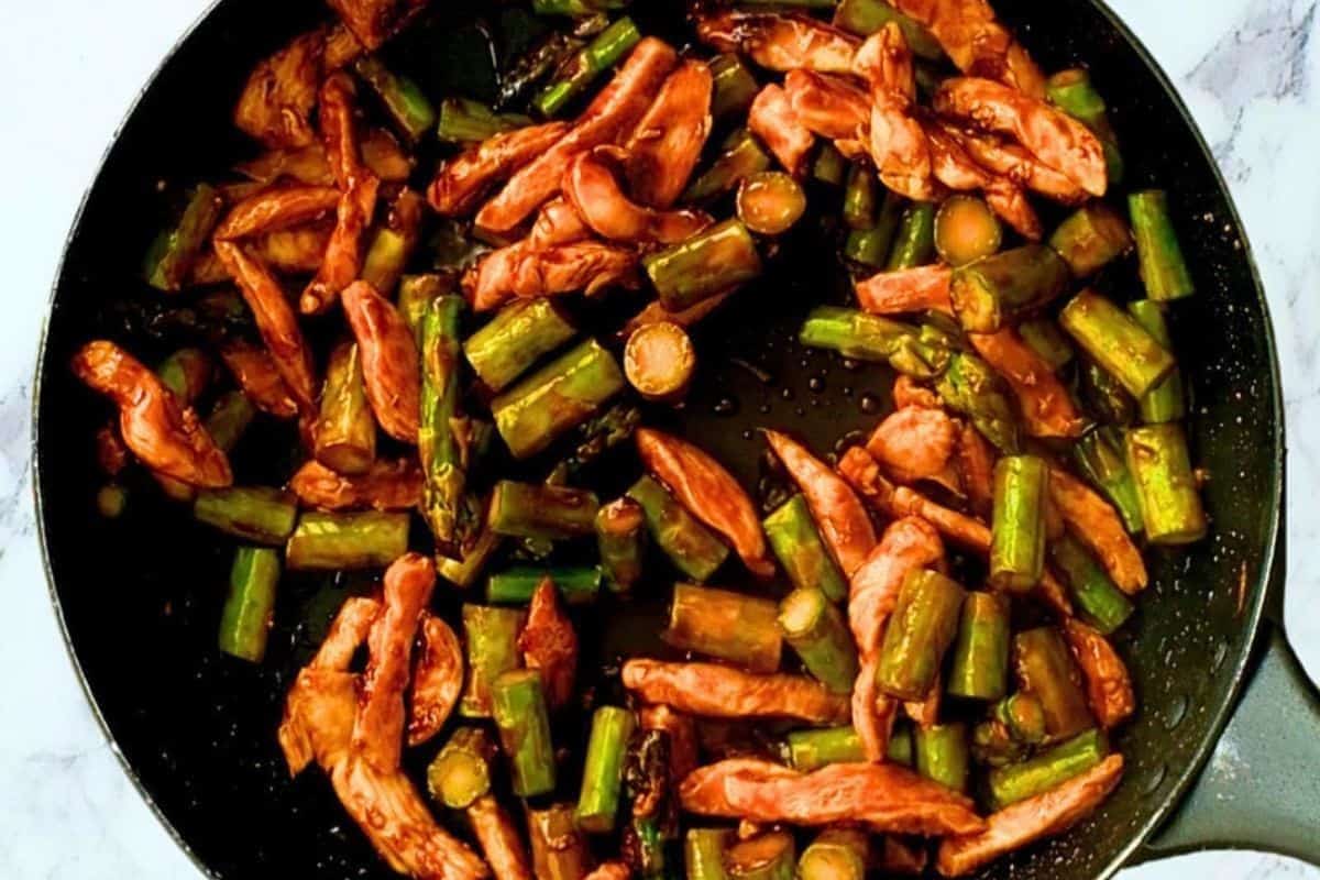 Stir-fried chicken and asparagus tossed in a savory sauce with colorful vegetables.