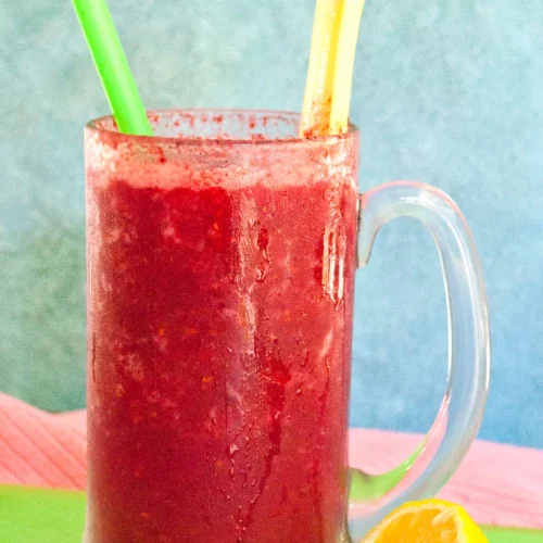 A Apple Berry Detox Smoothie garnished with lemon and celery