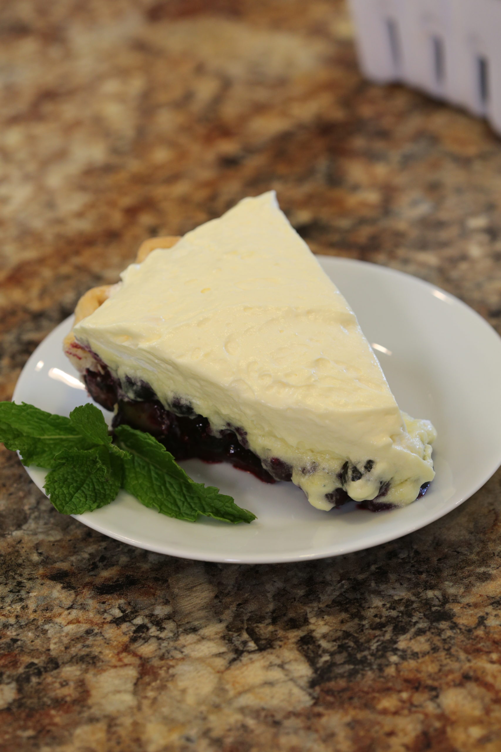 A white plate with Blueberry Cream Pie.