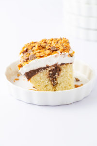 A butterfinger cake in a round dish.