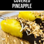 Close-up of chocolate-covered pineapple slices on a wooden surface, topped with toasted coconut flakes. A label above proudly reads "CHOCOLATE COVERED PINEAPPLE.