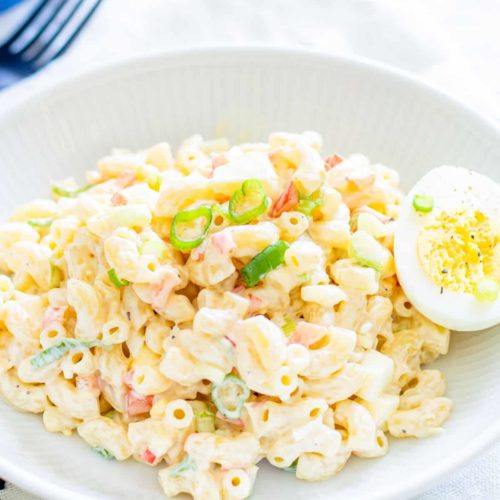Chilled macaroni salad in a bowl with egg and scallions