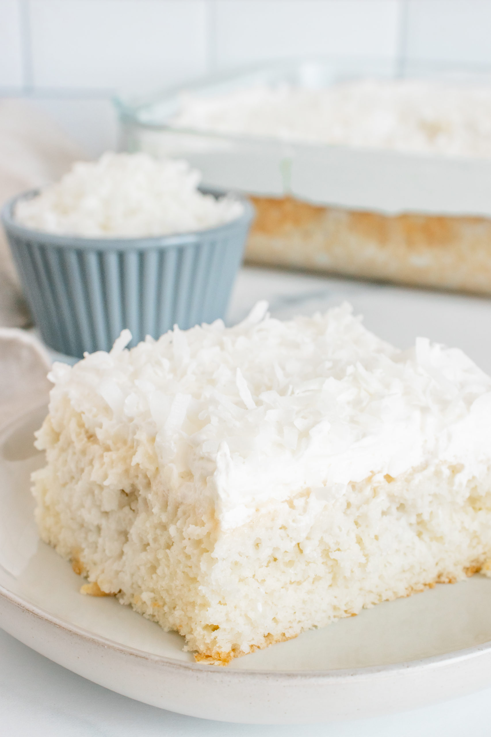 Coconut Poke Cake with a full cake in the background.