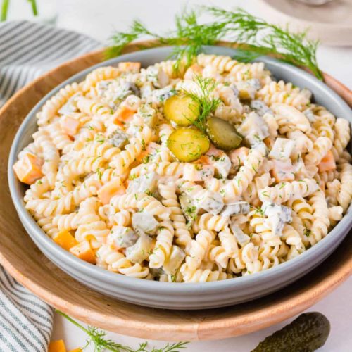 Large plate of pasta salad with a mayonaise dressing, pickles and dill