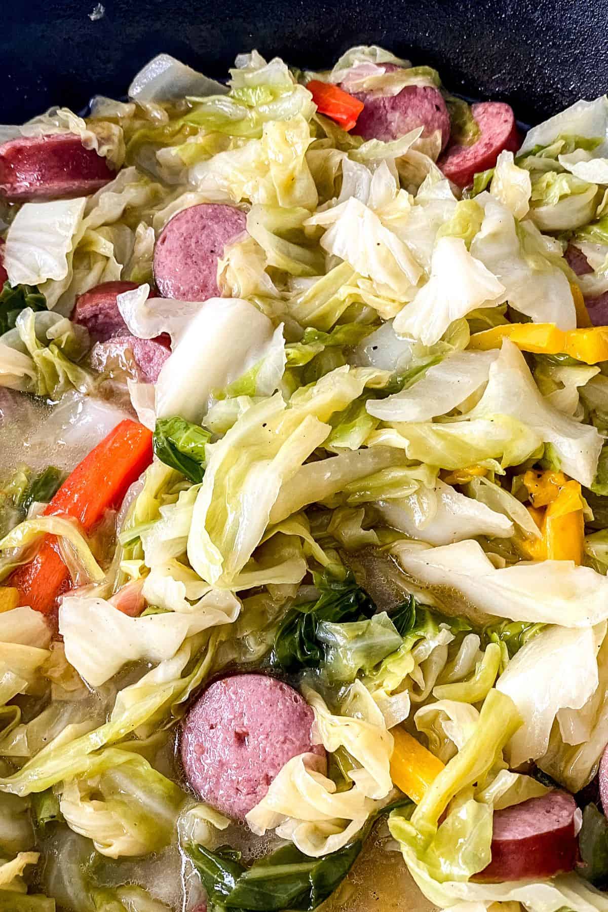A close-up featuring sliced meat and bell peppers mixed together in a pan.