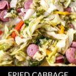A skillet filled with cooked cabbage, sliced sausage, and bell peppers. Text at the bottom reads: "Fried Cabbage and Sausage.