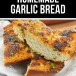 Three slices of crispy Homemade Garlic Bread garnished with herbs, arranged on a white plate.