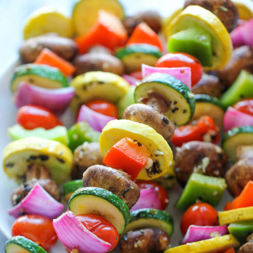Grilled vegetables on skewers in a plate
