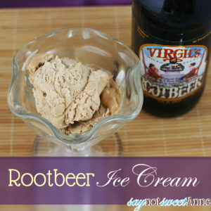 A glass bowl filled with root beer ice cream. A glass of root beer is next to the bowl.