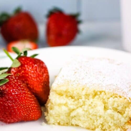 A piece of lazy cake with fresh strawberries on a white plate.