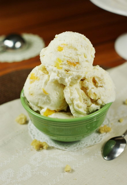 A bowl with several scoops of peach cobbler ice cream