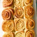 A glass baking dish filled with nine golden-brown, spiral-shapes arranged in a 3x3 grid.
