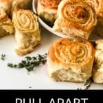 A plate and table topped with cheesy Pull Apart Pizza Bread rolls, garnished with fresh herbs. Text at the bottom reads "Pull Apart Pizza Bread.