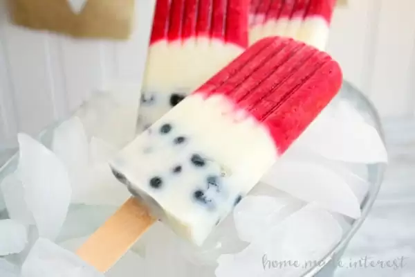 Red and white popsicles with blueberries on the bottom