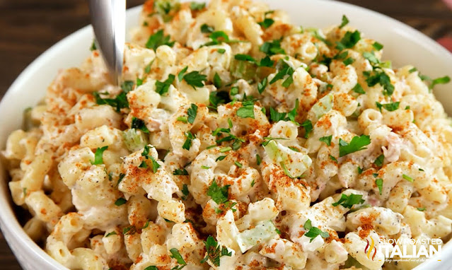 Macaroni salad seasoned with paprika and garnished with green herbs