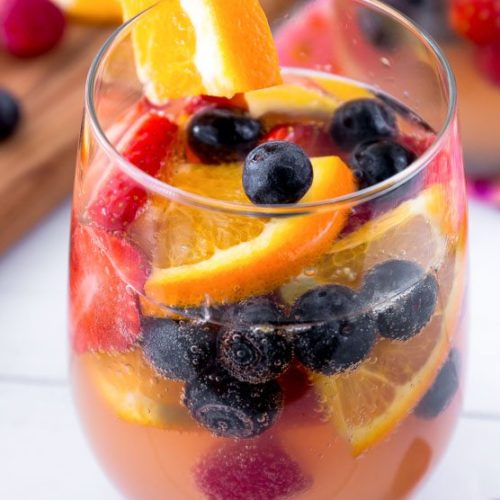A glass of Sparkling Champagne Sangria filled with fruit