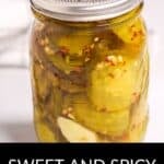 A glass jar filled with sliced pickles, spices, and brine, labeled as Sweet and Spicy Pickles for a perfect balance of tangy and bold flavors.