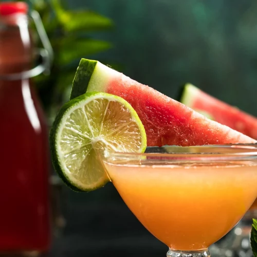 A Watermelon Whiskey garnished with a lime and watermelon