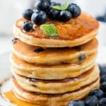Whole Wheat Blueberry Pancakes stacked on a platter.