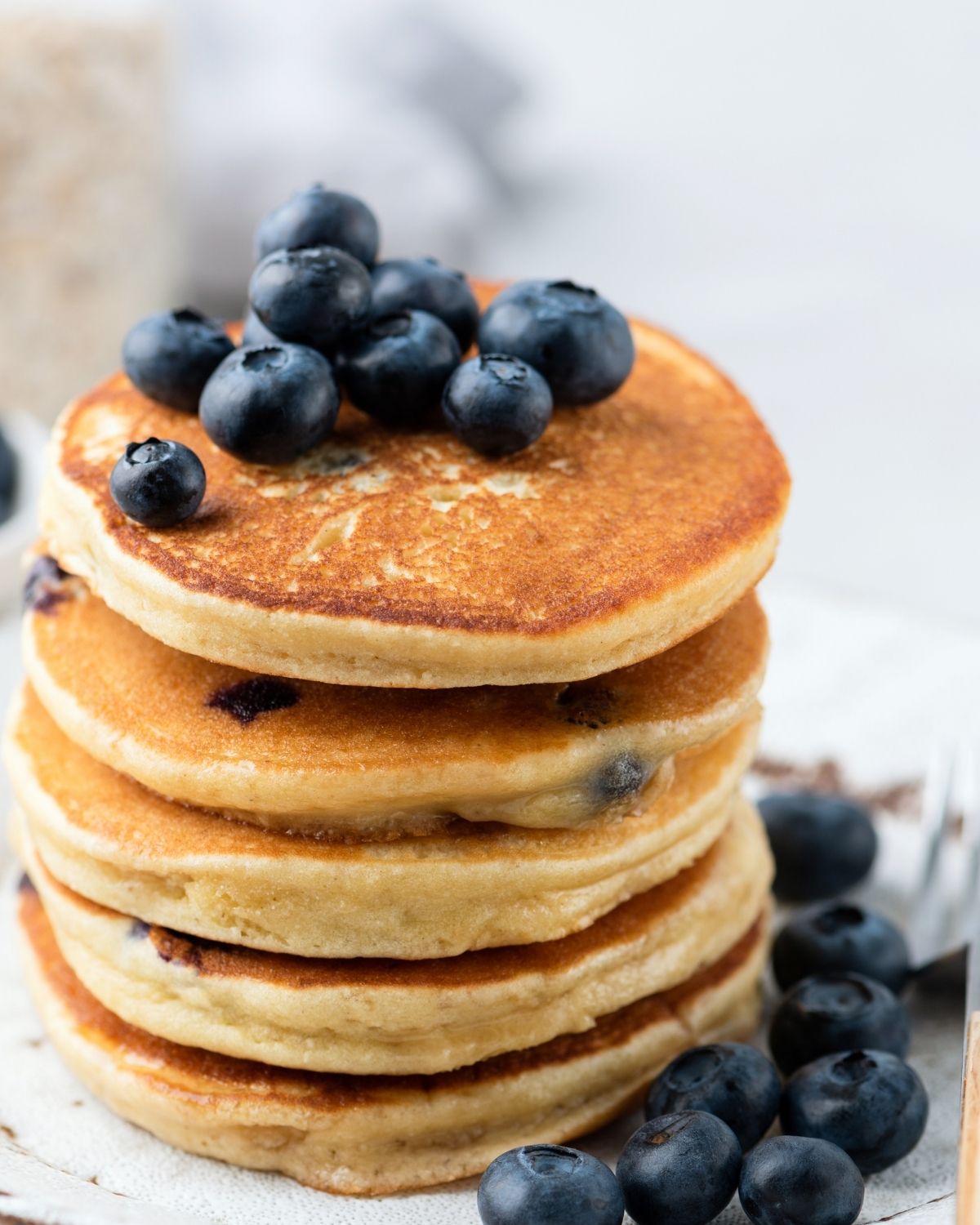A side view of the pancakes. Surrounded by blueberries.