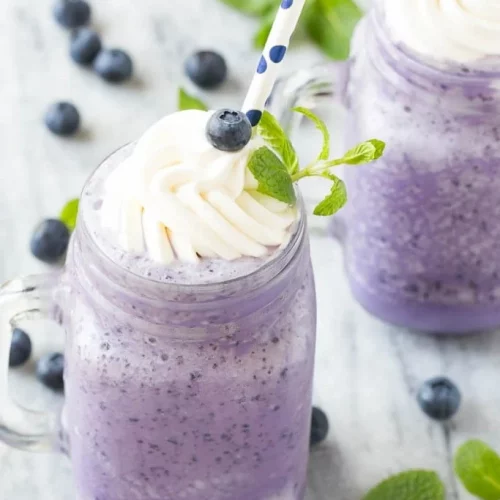 Blueberry milkshake garnished with whipped cream