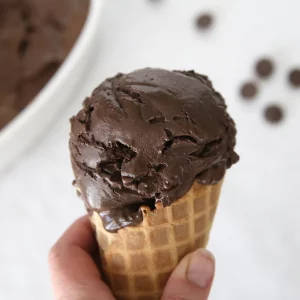 A closeup of a waffle cone with dark chocolate ice cream