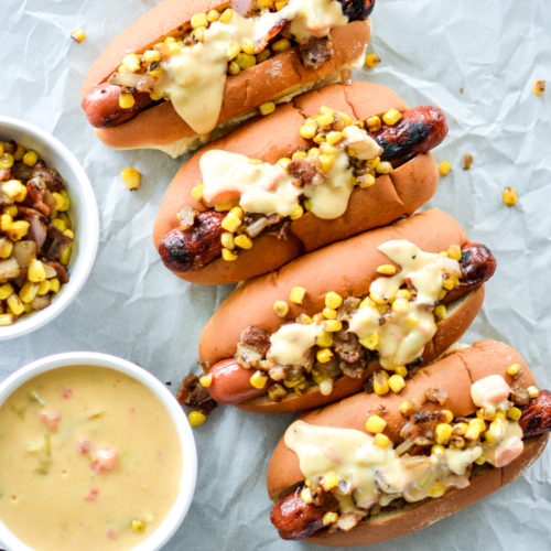 Hot dogs covereed in cheese sauce and corn