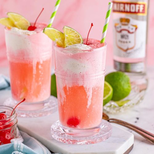 2 beautiful Dirty Shirley Floats garnished with a cherry and some limes