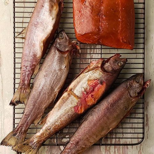 Several smoked trouts on a wire rack
