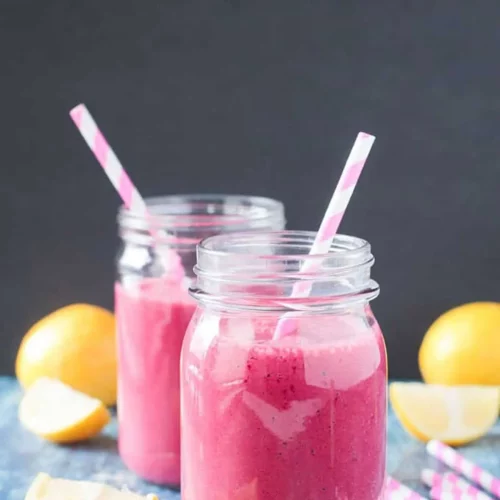 Two Strawberry Beet Smoothies garnished with lemons