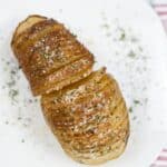 A plate with the vegetable sliced thinly and baked to perfection, topped with herbs and grated cheese.