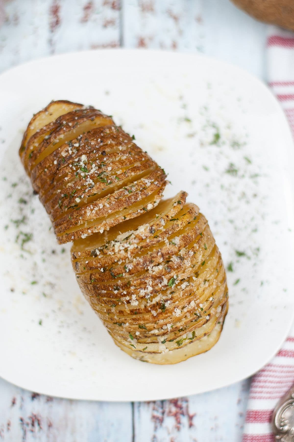 A plate with the vegetable sliced thinly and baked to perfection, topped with herbs and grated cheese.