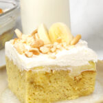 Banana Cream Poke Cake with a glass of milk.